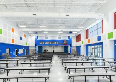 school auditorium with tables, stage and a piano forte on stage